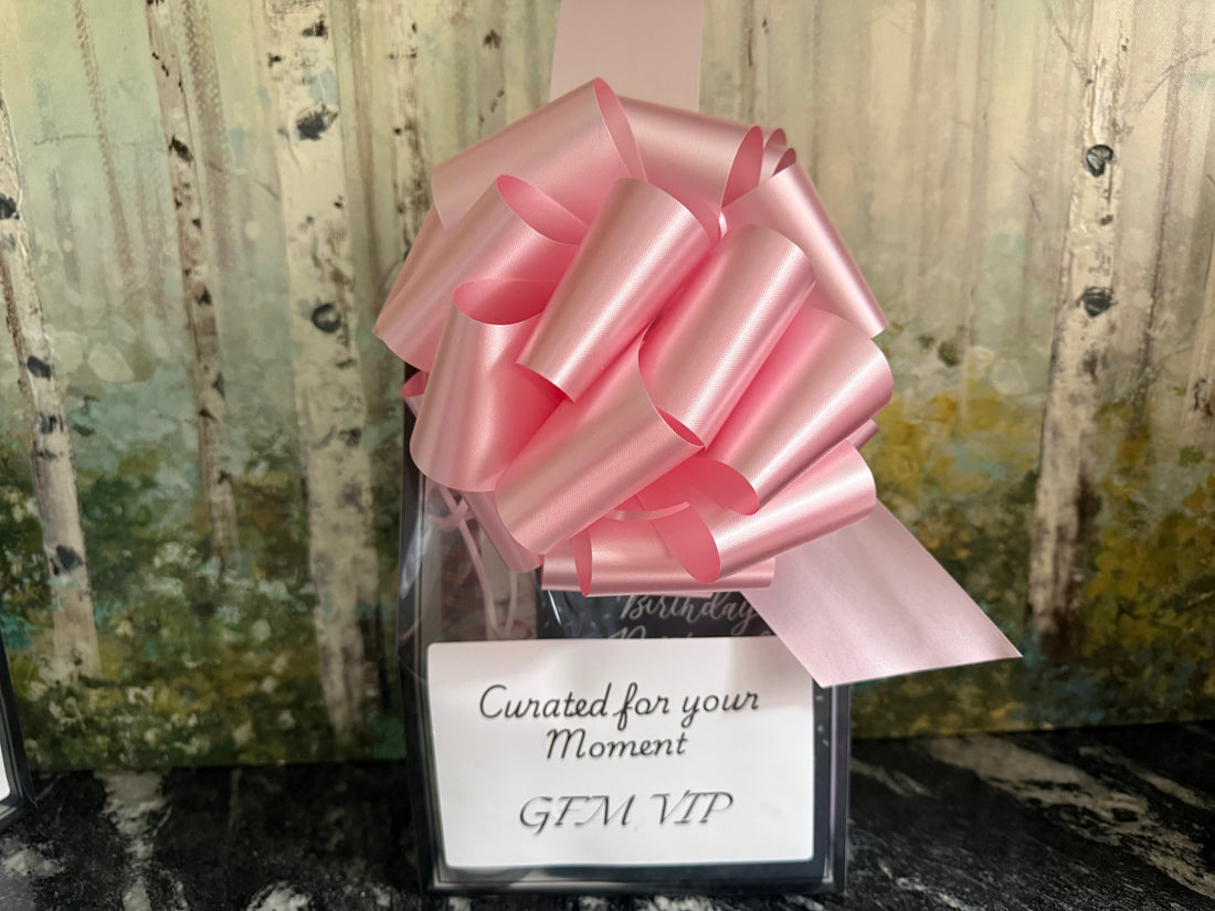 Gift with a pink bow and a card reading 'Curated for your Moment GEM VIP' against a natural background.
