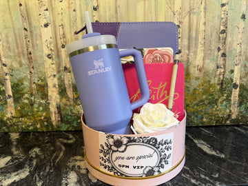 Purple Stanley mug with a decorative container holding a rose and a faith bible cover 