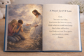 Open book with a painting of Jesus comforting two people and a prayer 